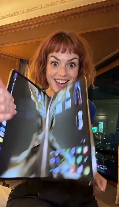 AI-generated woman with a copper-brown bob, blue short-sleeved top and dark trousers