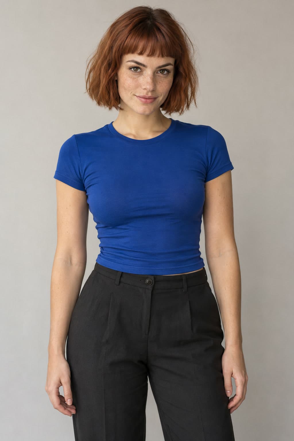 AI-generated woman with a copper-brown bob, blue short-sleeved top and dark trousers